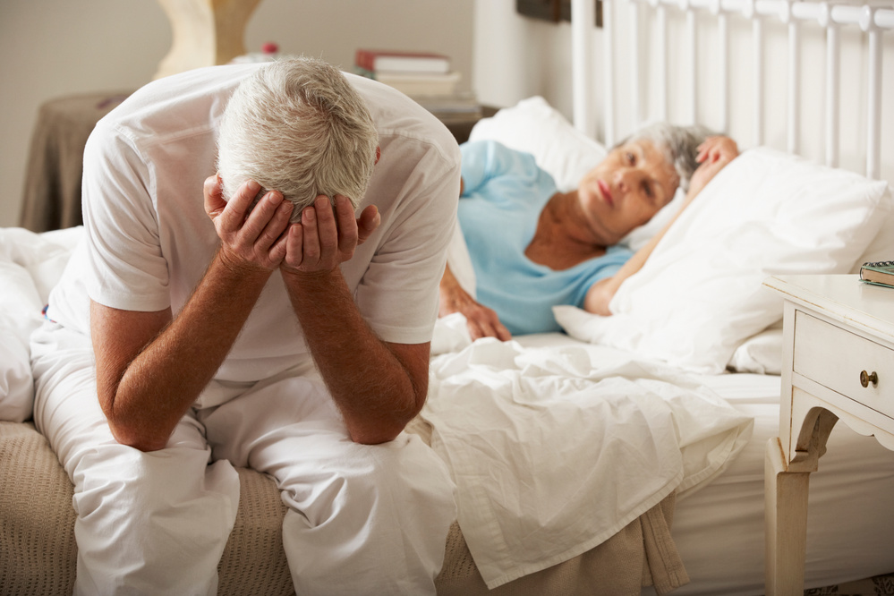 Senior Man Sits on Bed